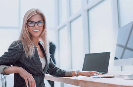 businesswoman sitting at her Desk and looking at the camera