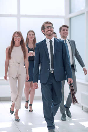 businessman walking in front of his business teamの写真素材