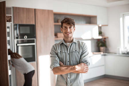handsome young man standing in his kitchen.の写真素材