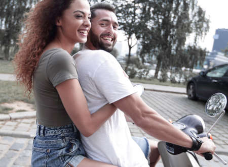 Full length side view of happy couple riding on retro motorbikeの写真素材