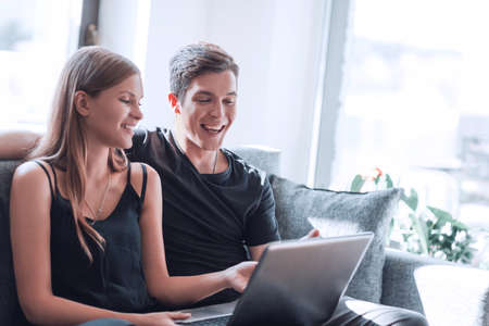 close up. young couple using laptop sitting on sofaの写真素材