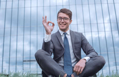 happy businessman showing OK gesture sitting near his officeの写真素材
