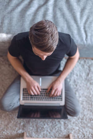 top view. young man typing on laptop keyboardの写真素材