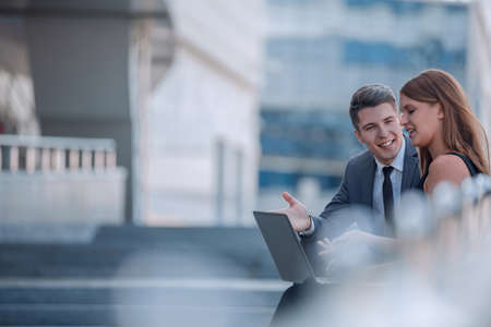 beautiful corporate couple sitting on the street of the evening city.の写真素材
