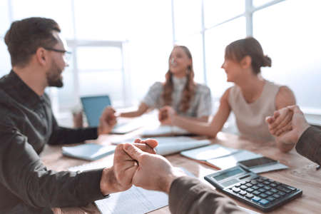 business team sitting at the table and showing their unityの写真素材