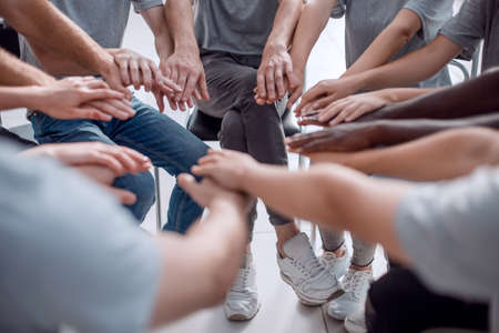close up. a group of diverse young people holding hands