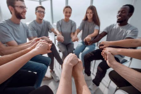 close up. a group of diverse young people holding hands
