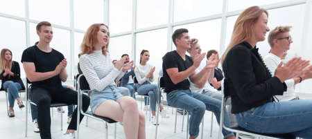 rear view. young people applaud during the youth seminar.