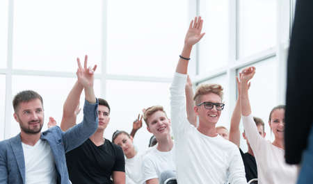 group of young people raising their hands to ask a question.