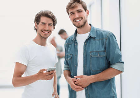 two coworkers standing in the office hallway.の写真素材