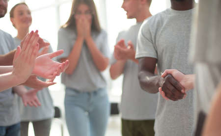 Contact group of young people applauding their coachの写真素材