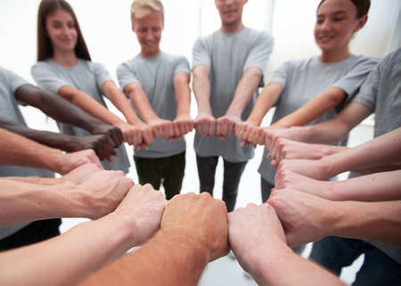 group of young people making a circle out of their hands