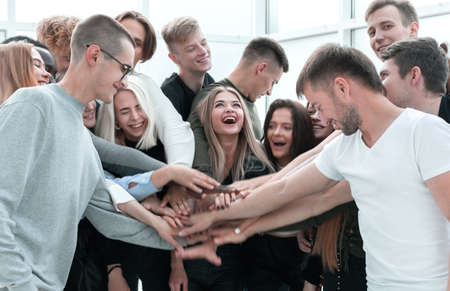 large group of young people joining their hands together.の写真素材