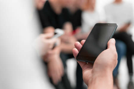 close up.the image of a smartphone in the hands of a young man. photo with copy spaceの写真素材