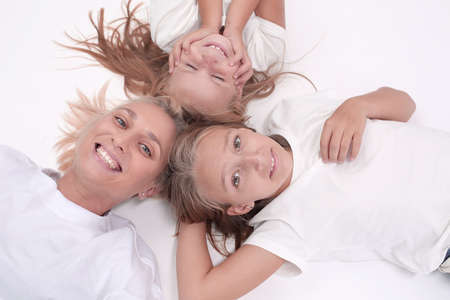 happy mother and daughters lying down togetherの写真素材