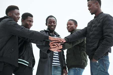 close up. group of guys putting their hands together.の写真素材