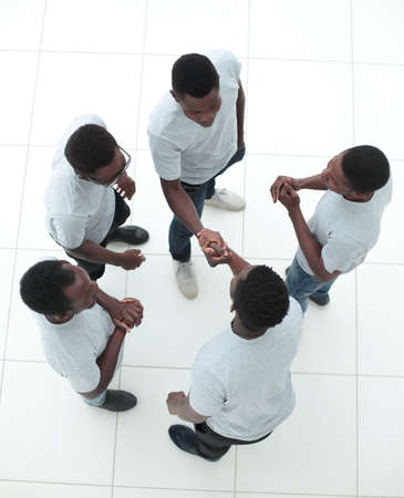 top view. guys shaking hands standing among their friendsの写真素材