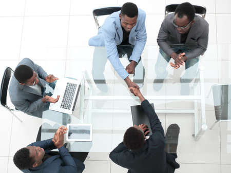 top view. business partners shaking hands during negotiations in the officeの写真素材