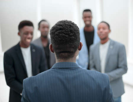 young businessman standing in front of his business team