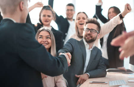 Manager congratulating a young employee in the workplace.の写真素材