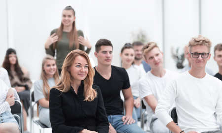 young woman asks a question to the speaker during the seminar. business and education