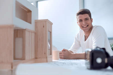 smiling confident man sitting at the table in the design Studio