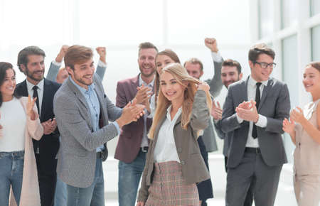 happy young woman standing in front of her jubilant colleagues