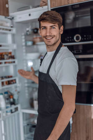 attractive young man standing near the kitchen tableの写真素材