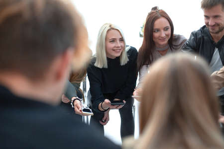 group of young people with smartphones sitting at a table.