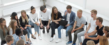 large group of diverse young people sitting in a circle