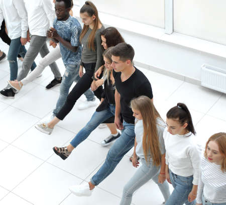 diverse young people standing in a row and pointing to a copy of the space