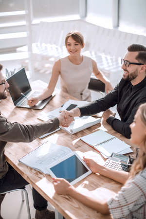 smiling business partners shaking hands at a business meeting.の写真素材