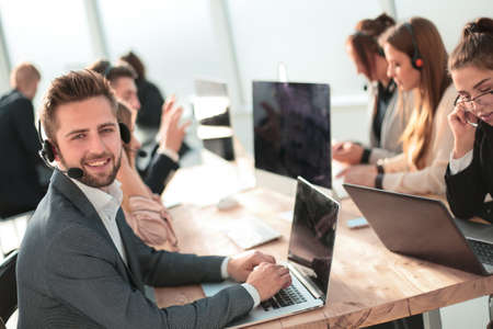 young customer service representative sitting behind a Desk