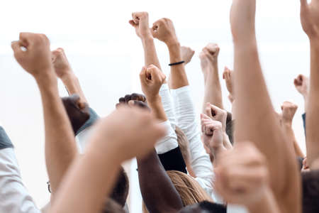 close up.cropped image of a multiracial group of people holding their hands up.