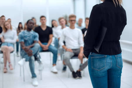 young woman standing in front of the audience in the conference roomの写真素材