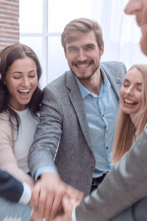 close up. happy business team joining their hands together.の写真素材
