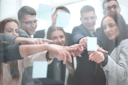 group of employees pointing at a sticky note.