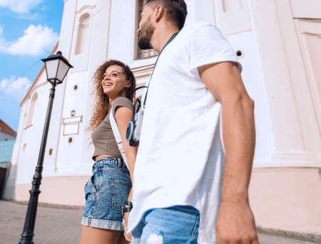 A couple is walking along the streets of the city and having fun