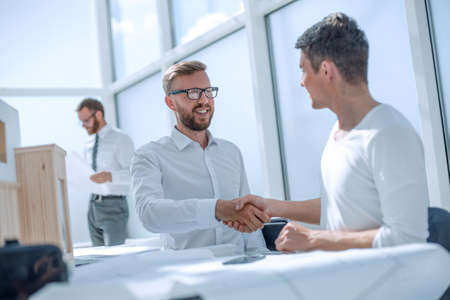 colleagues shaking hands in the creative officeの写真素材