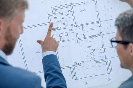 architect discussing with the client a blueprint of the project.