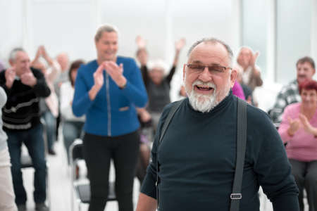 Smiling man gives a speech in meeting