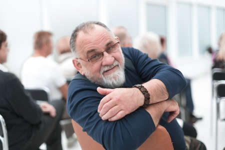 Man at a meeting looks at camera