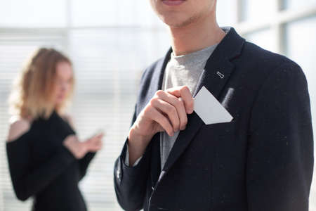 Young business man holding white business card on modern office blur background.の写真素材