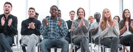 smiling young people applauding at a business seminar.の写真素材