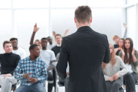 speaker and a group of diverse young listeners in a conference roomの写真素材