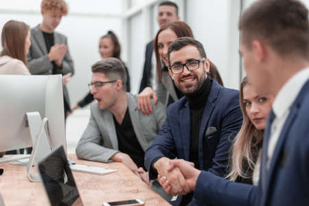 business people shaking hands sitting at the office Desk.