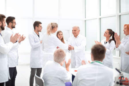 group of scientists congratulating their colleague in the workplaceの写真素材
