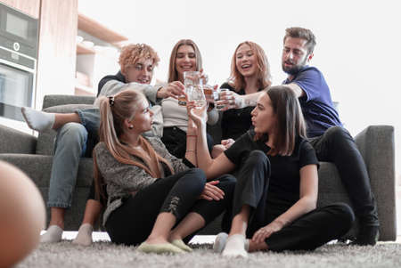 Cheerful friends having fun time and drinking at home