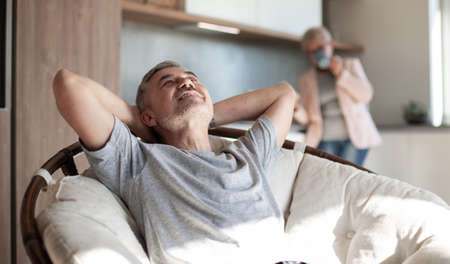 mature man dreaming sitting in a cozy papasan chair . photo with a copy-space.の写真素材