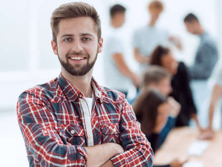 smiling young man standing in a modern office